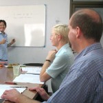 Thai teacher K. Tin teaching the basics of the Thai language to two students