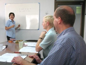 Thai teacher K. Tin teaching the basics of the Thai language to two students